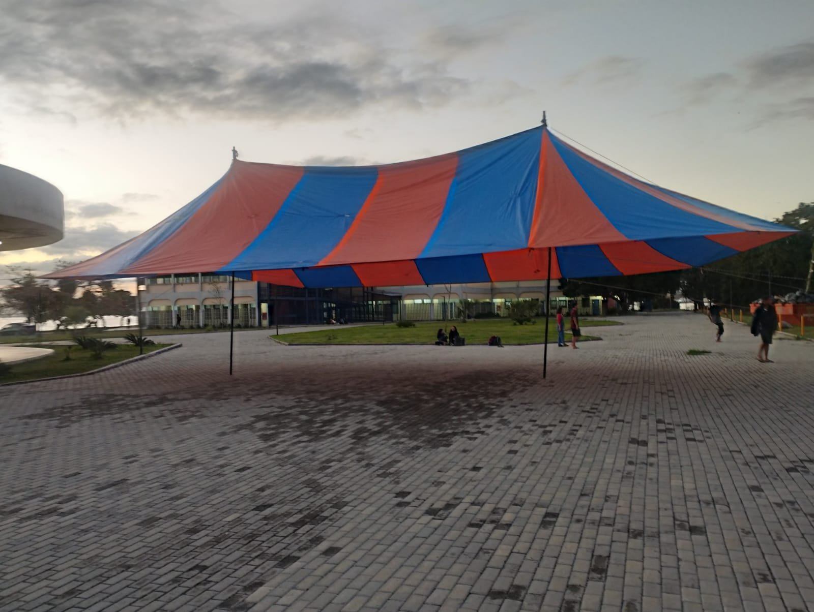 Tenda tensionada grande azul e laranja em evento ao ar livre